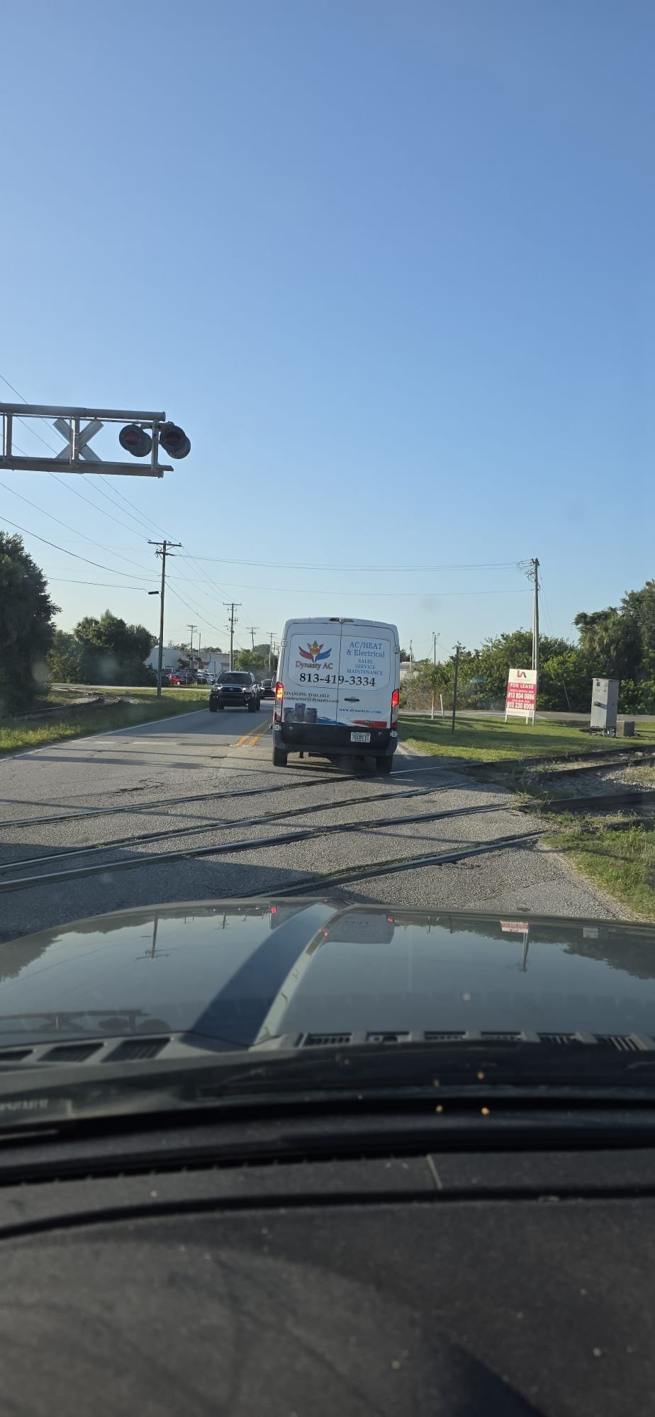 Dynasty AC branded service van on the road, signage and phone number visible