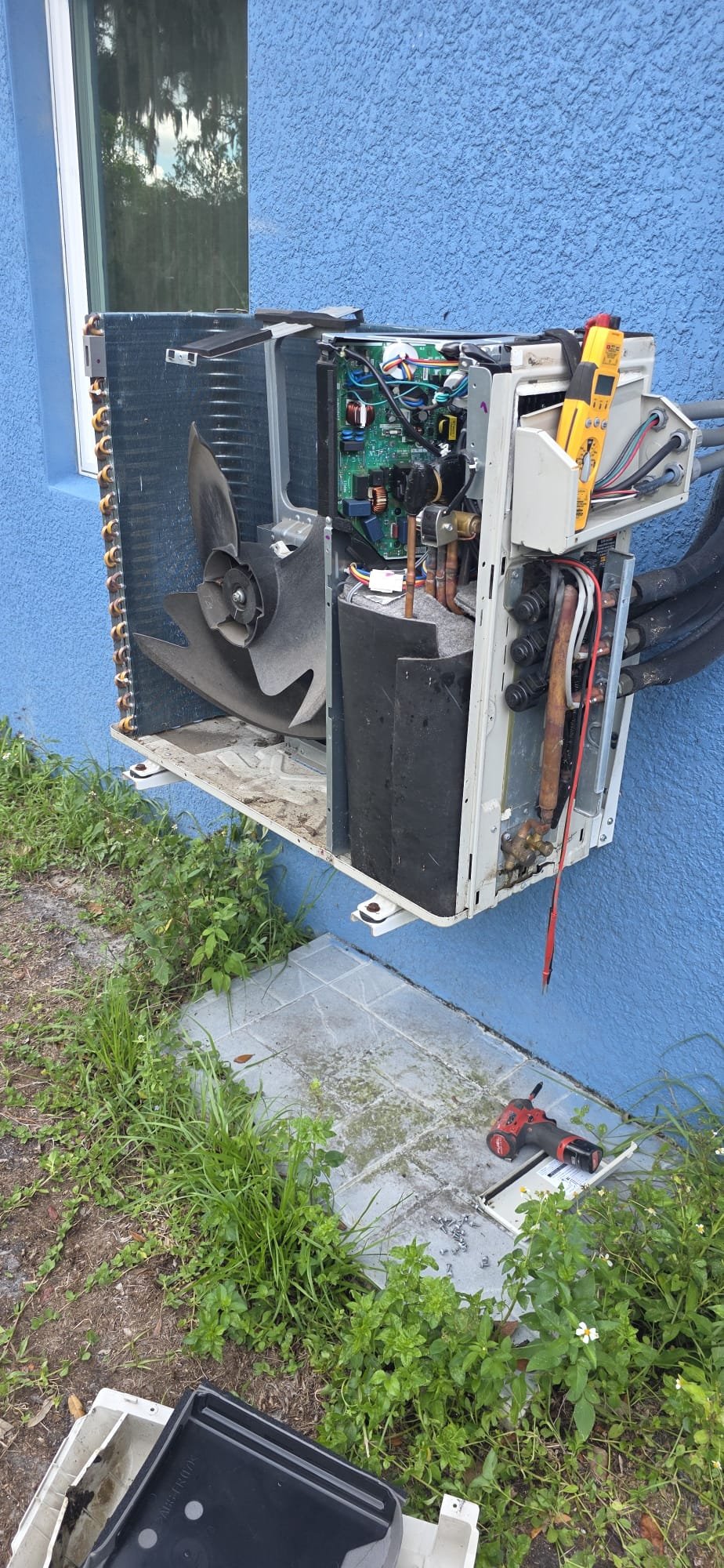 Dynasty AC technician mid-repair on an open mini-split condenser control panel