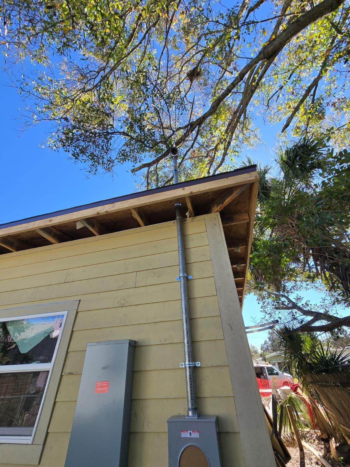 Electrical meter panel and conduit mast installed on exterior wall of a house