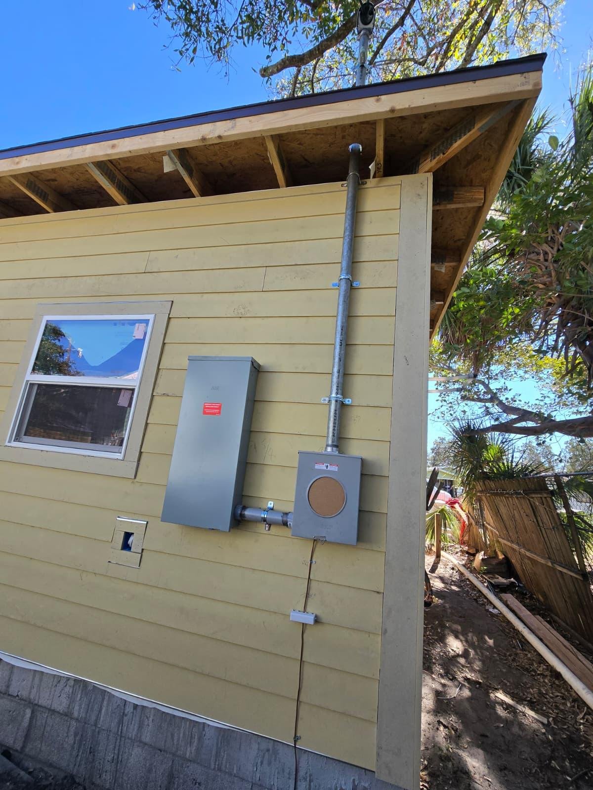 New electrical disconnect panel and meter base mounted on exterior wall of a home