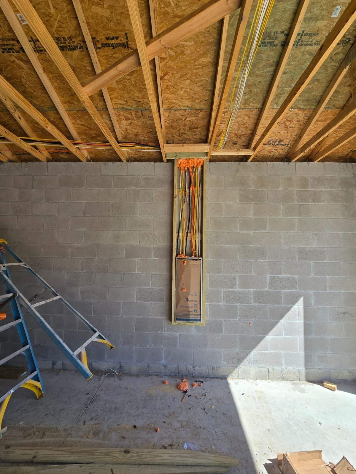 Electrical wiring rough-in from attic framing to a panel box in new construction