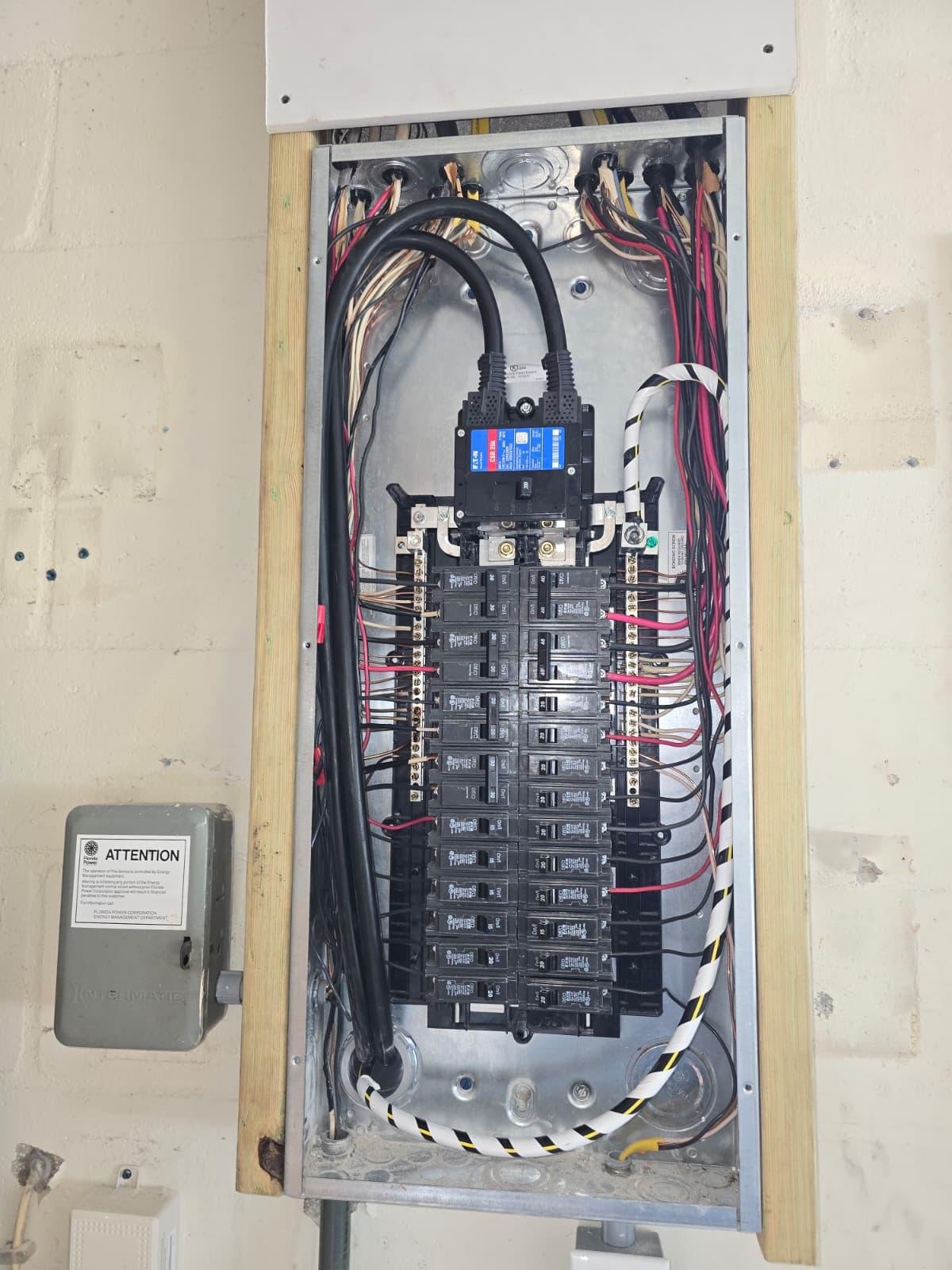 Open residential electrical panel with breakers and wiring on exterior wall