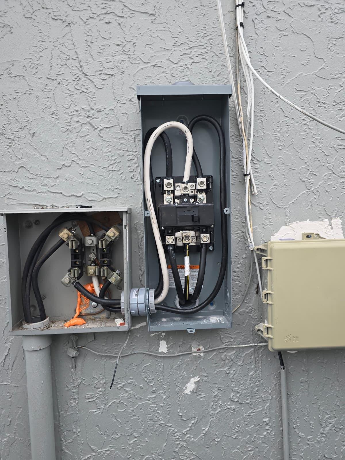 Open exterior electrical meter panel and disconnect box on a home's wall