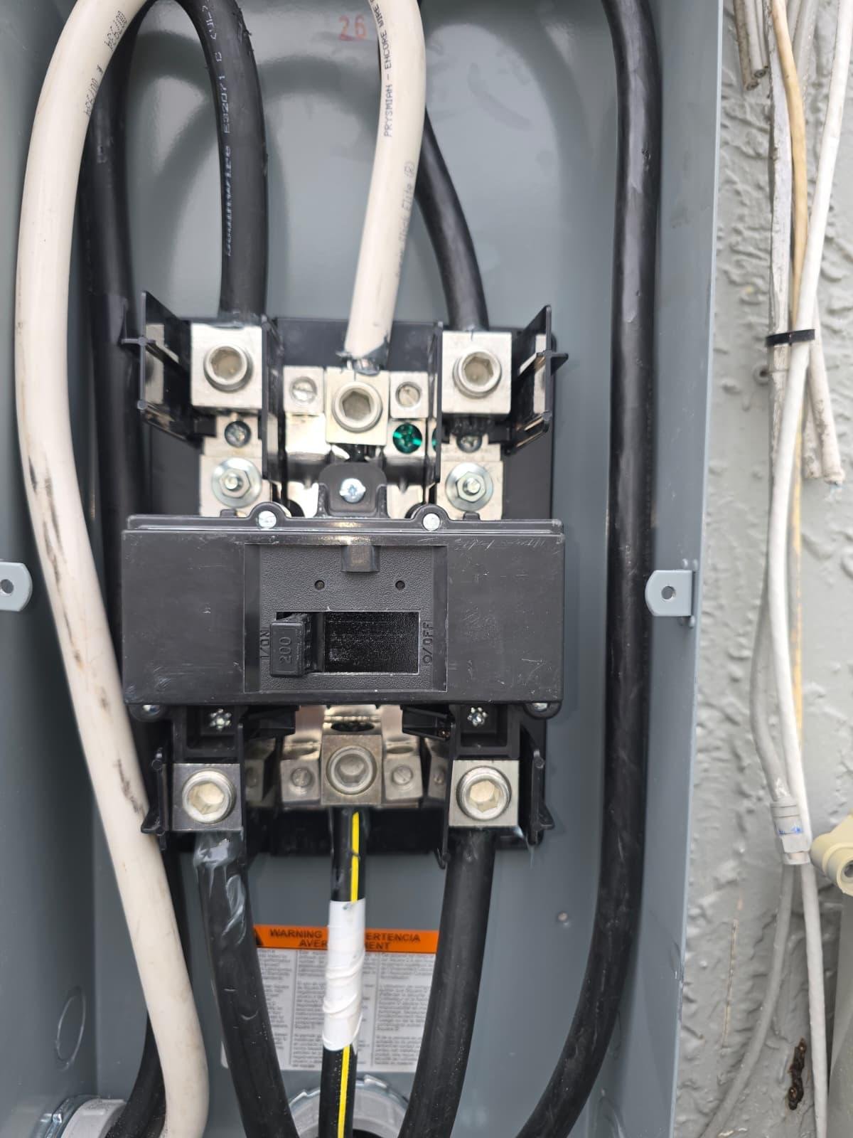 Open electrical panel interior showing 200-amp main breaker and service wiring
